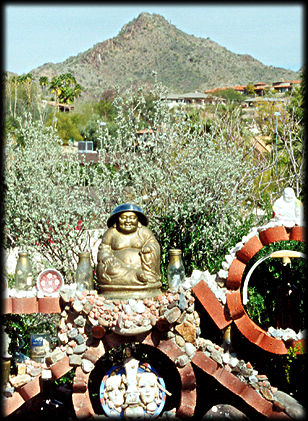 A small gleaming Buddha is framed by one of the peaks of the Phoenix Mountains.