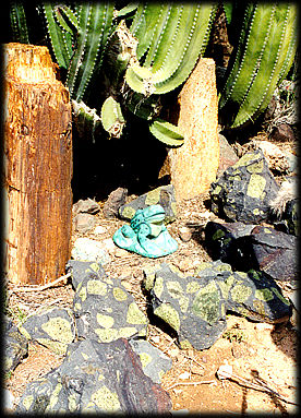 A frog guards boulders filled with Arizona Peridot from San Carlos, Arizona at Somewhere over the Rainbow Rock Garden, in Phoenix, Arizona.