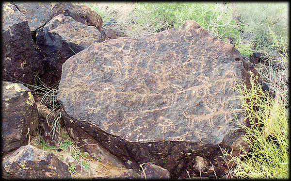Ancient rock art petroglyphs decorate a basalt boulder at the Deer Valley Rock Art Center, near Phoenix, Arizona.